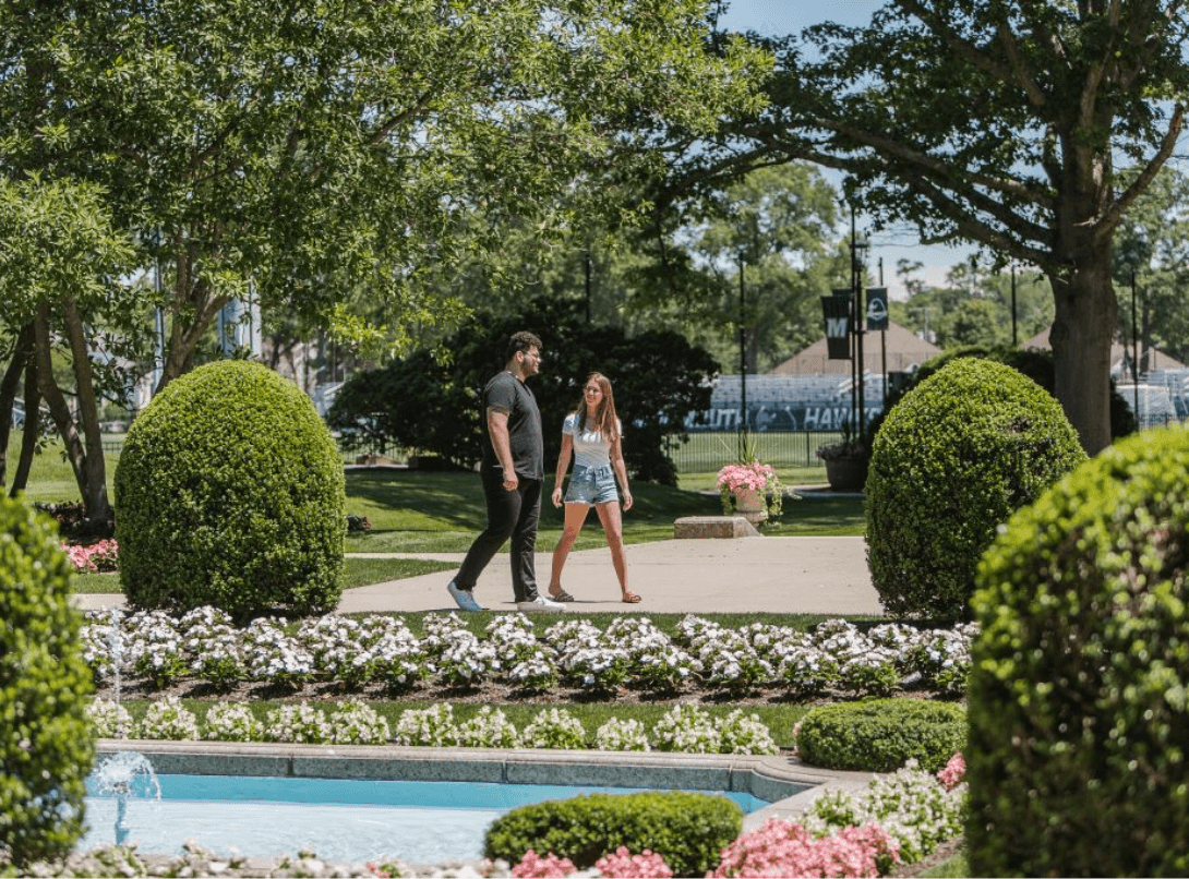 Two students walking through Erlanger Gardens on campus.